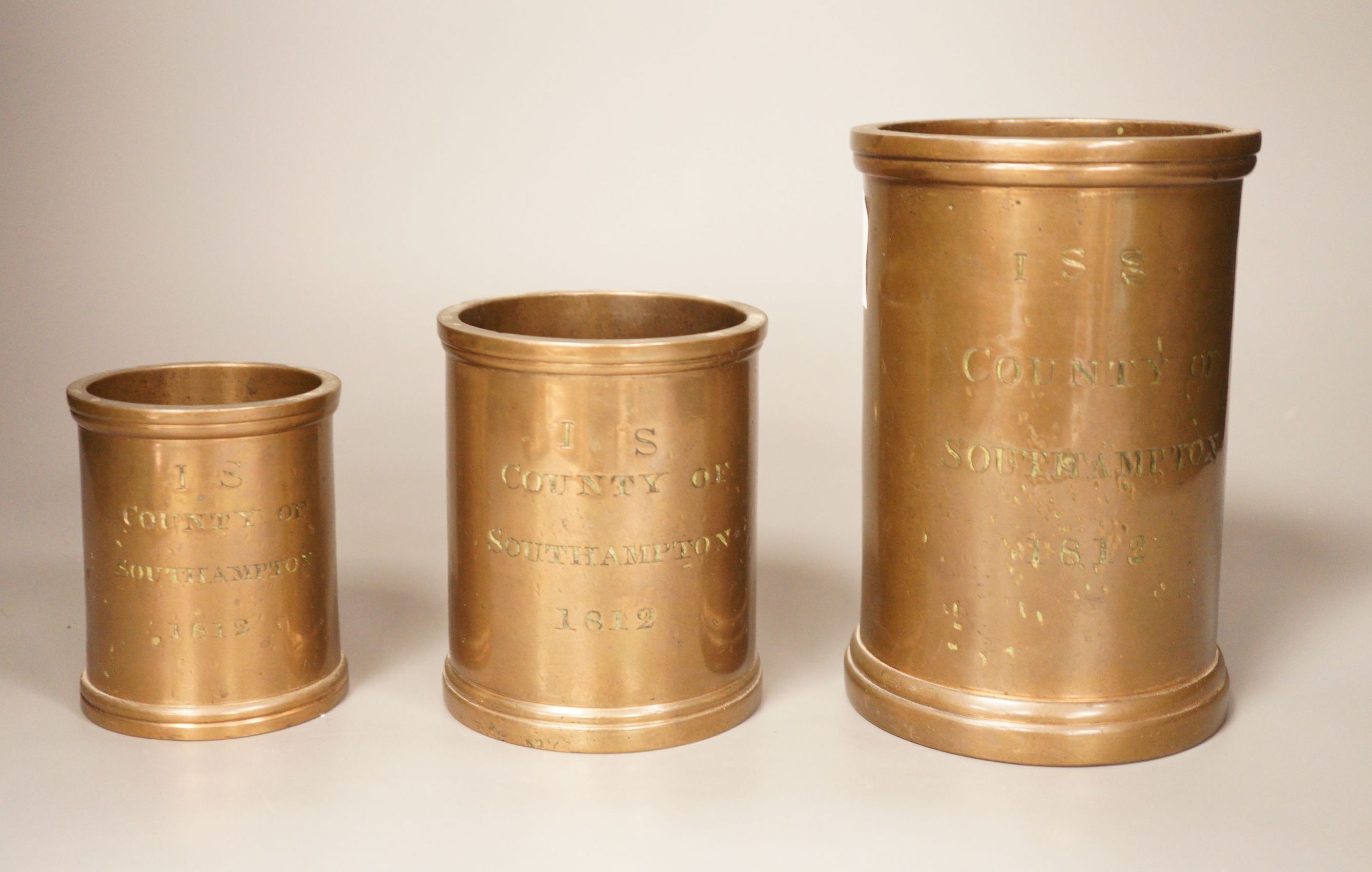 Three early 19th century graduated bronze measures, the larger marked ‘quart Winchester’, the others marked ‘County of Southampton, 1812 (3). 17cm